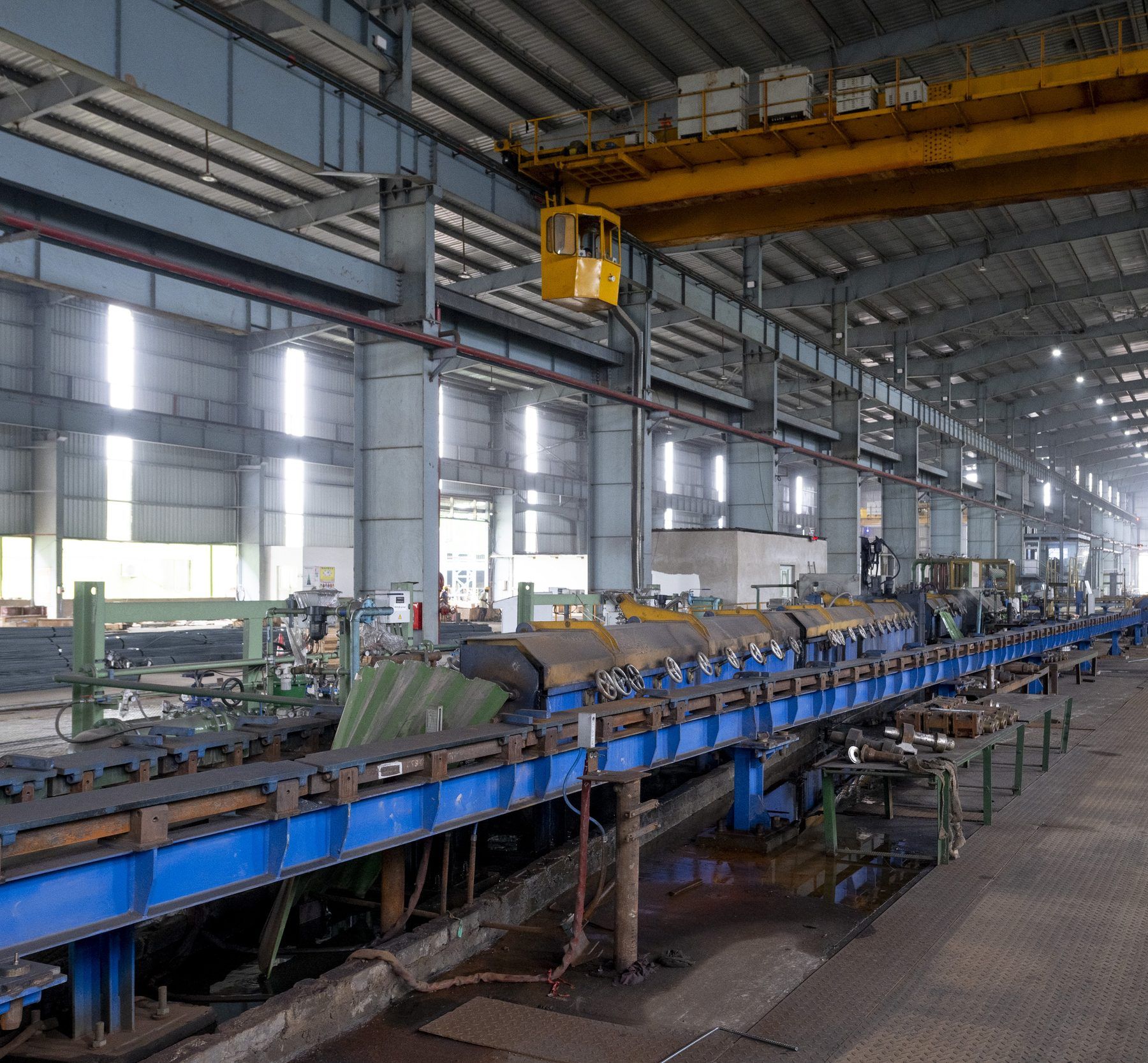 Inside the Jatia Steel rolling mill hall with the rolling line and overhead crane